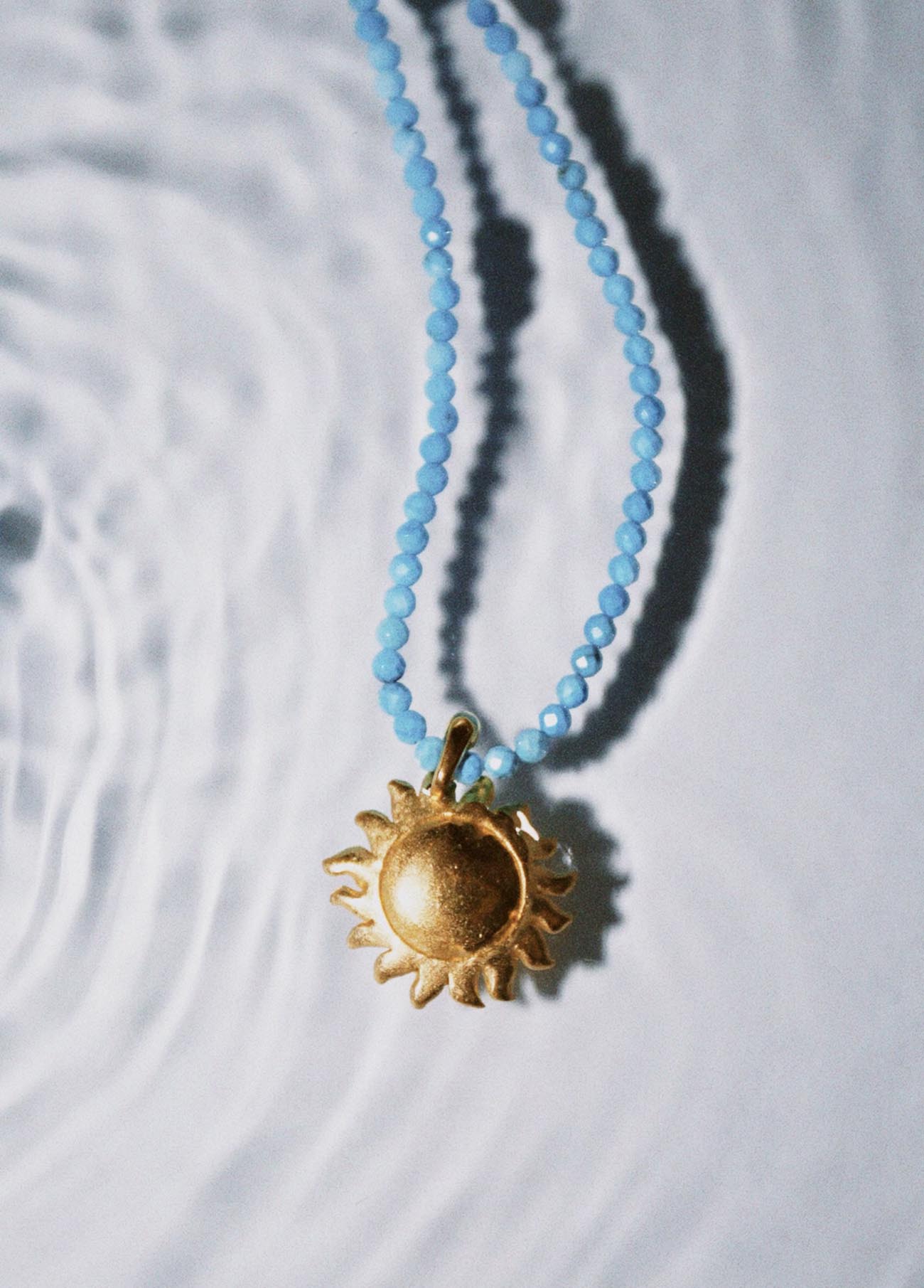turquoise choker with golden sun charm